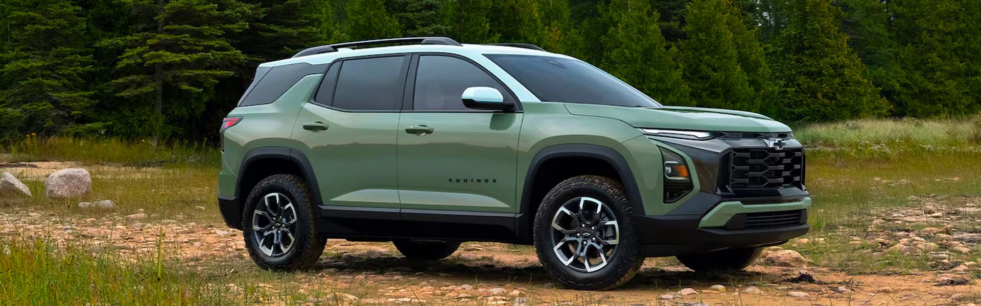 2026 Chevrolet Equinox compact SUV in green with black roof, parked outdoors showcasing rugged design and modern styling